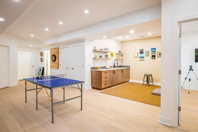 a living room with stainless steel appliances kitchen island granite countertop furniture and a dining table with wooden floor