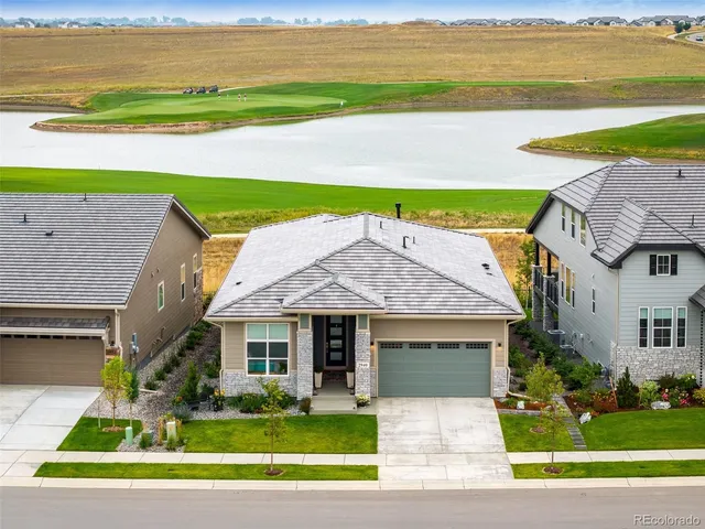 a front view of a house with a yard and ocean view