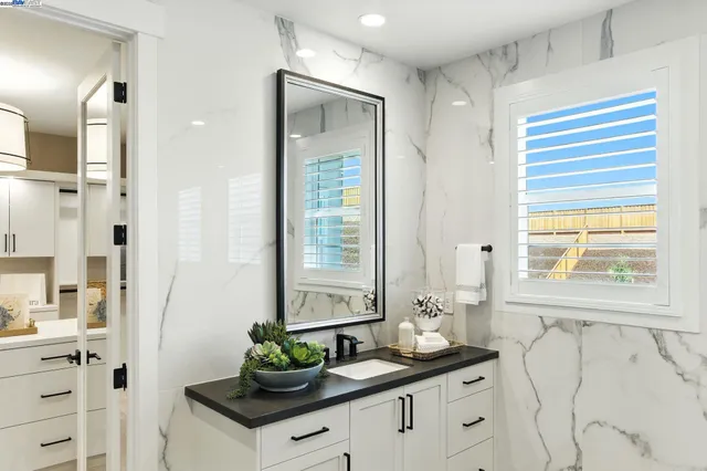 a bathroom with a granite countertop sink toilet a mirror and shower