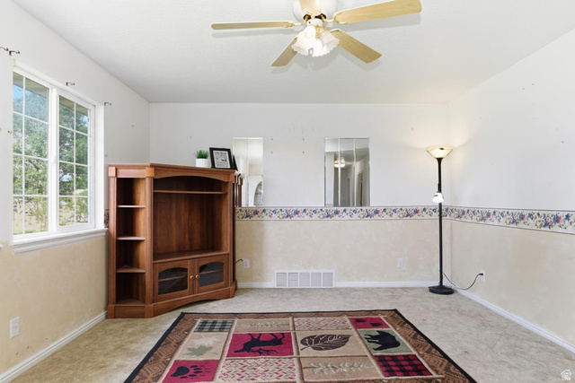435 East 4th North Preston, ID 83263 - Photo 4 of 26 Room featuring a ceiling fan, broad window, and neutral wall tones with a decorative border