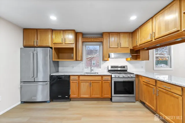 a kitchen with stainless steel appliances granite countertop a stove a sink dishwasher and a refrigerator
