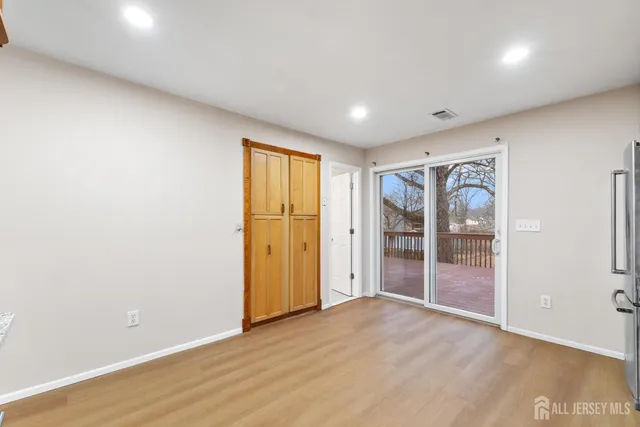 an empty room with wooden floor and sliding door