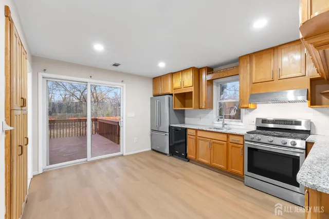 a kitchen with stainless steel appliances granite countertop a stove a sink and a refrigerator