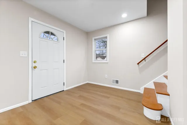 a view of an empty room with wooden floor