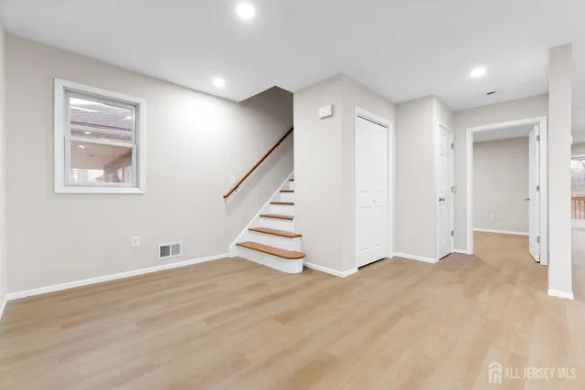 a view of an empty room with wooden floor and entryway