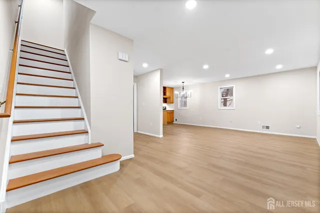 a view of a kitchen with wooden floor and stairs
