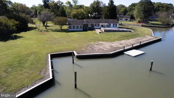 a view of a swimming pool with seating area and trees in the background
