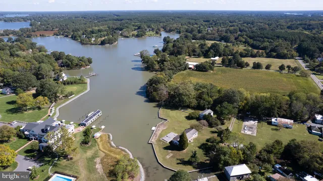 an aerial view of a house with a yard and lake view