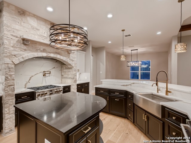 208 River Ridge Boerne, TX 78006 - Photo 12 of 38 a kitchen with stainless steel appliances granite countertop a sink a stove and a wooden cabinets