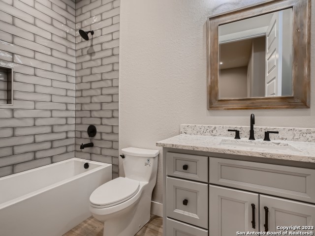 208 River Ridge Boerne, TX 78006 - Photo 22 of 38 a bathroom with a granite countertop toilet a sink and a bathtub