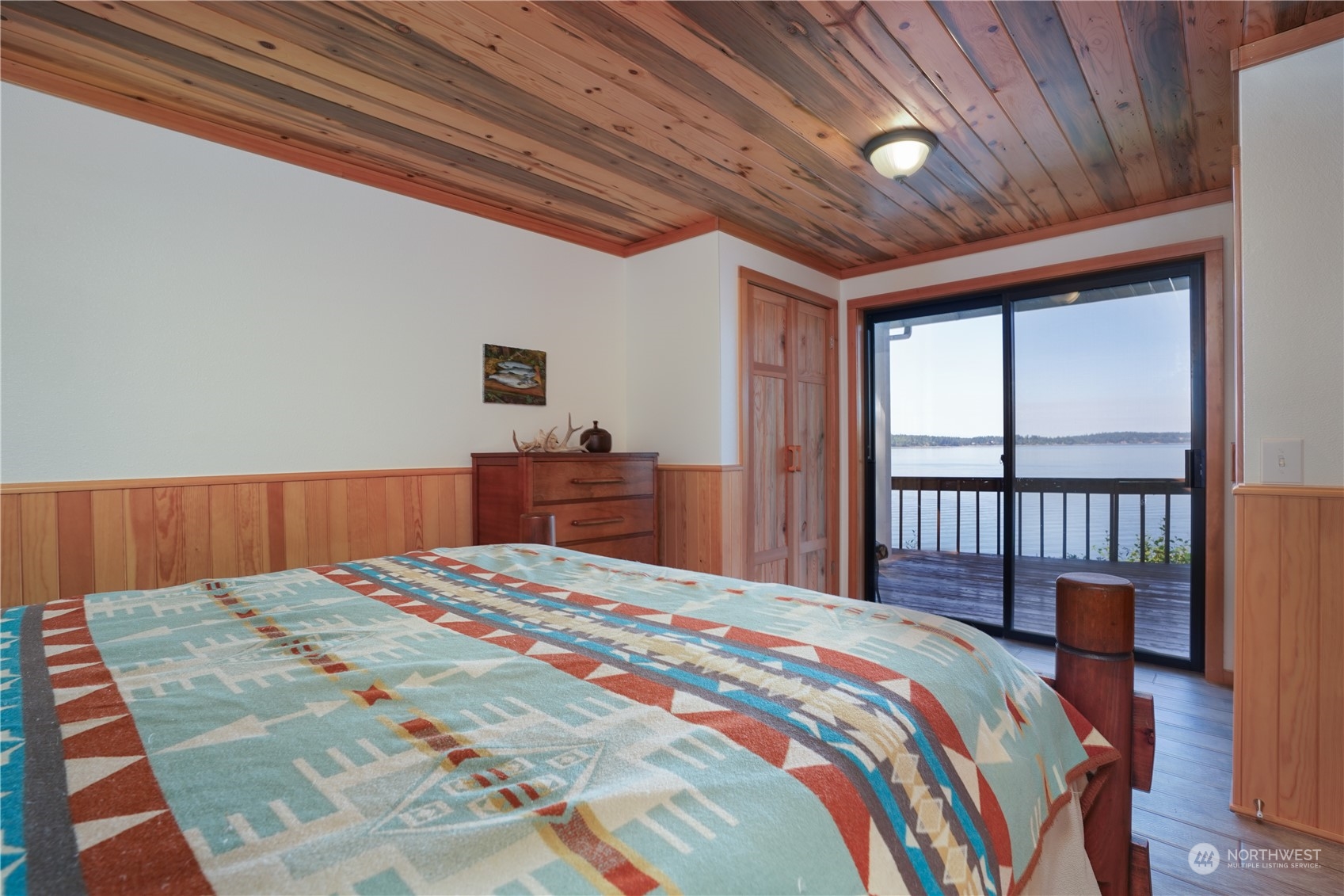 14507 Outer Bay Road Anderson Island, WA 98303 - Photo 20 of 40 a bedroom with a large bed and a large window