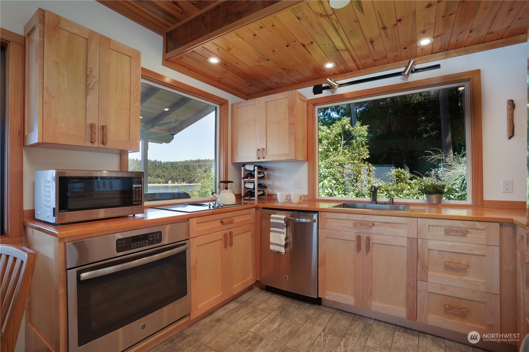 14507 Outer Bay Road Anderson Island, WA 98303 - Photo 10 of 40 a kitchen with stainless steel appliances granite countertop a stove a sink and a microwave