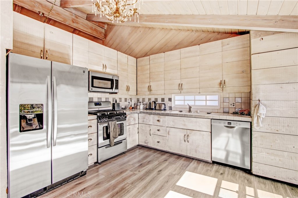 1486 Morningside Circle, Unit MAIN Laguna Beach, CA 92651 - Photo 16 of 24 a kitchen with granite countertop white cabinets and stainless steel appliances