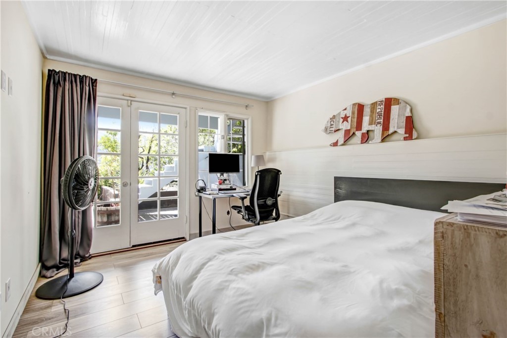 1486 Morningside Circle, Unit MAIN Laguna Beach, CA 92651 - Photo 22 of 24 a bedroom with a bed and glass door