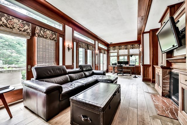a living room with furniture a large window and wooden floor