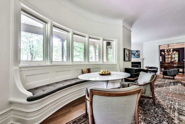 a kitchen with a stove a sink and a dining table with wooden floor