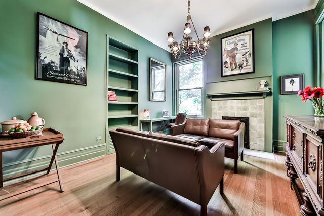 a living room with furniture a chandelier and a fireplace