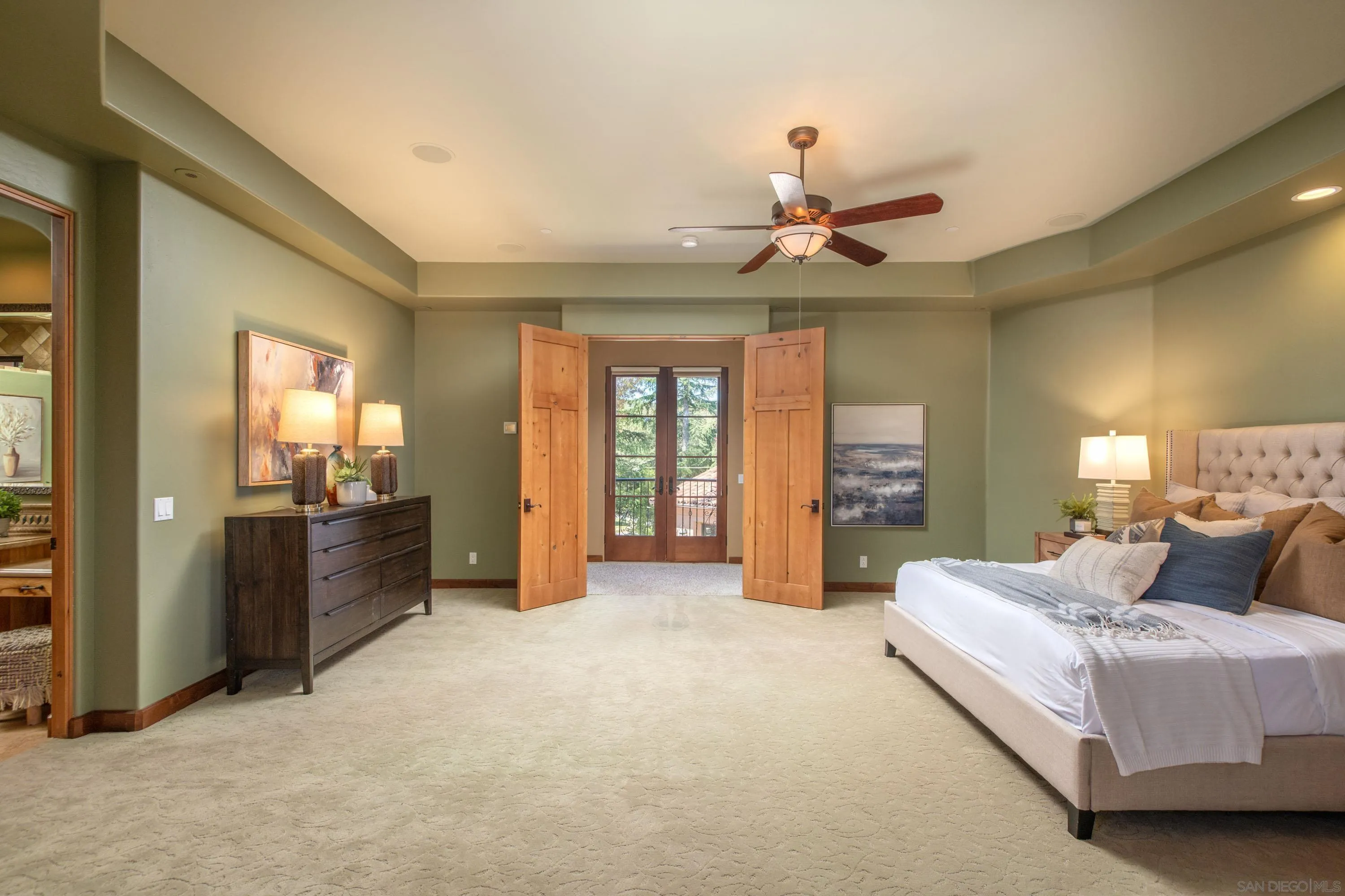 23835 Viejas Grade Road Descanso, CA 91916 - Photo 29 of 62 a spacious bedroom with a large bed and a chandelier