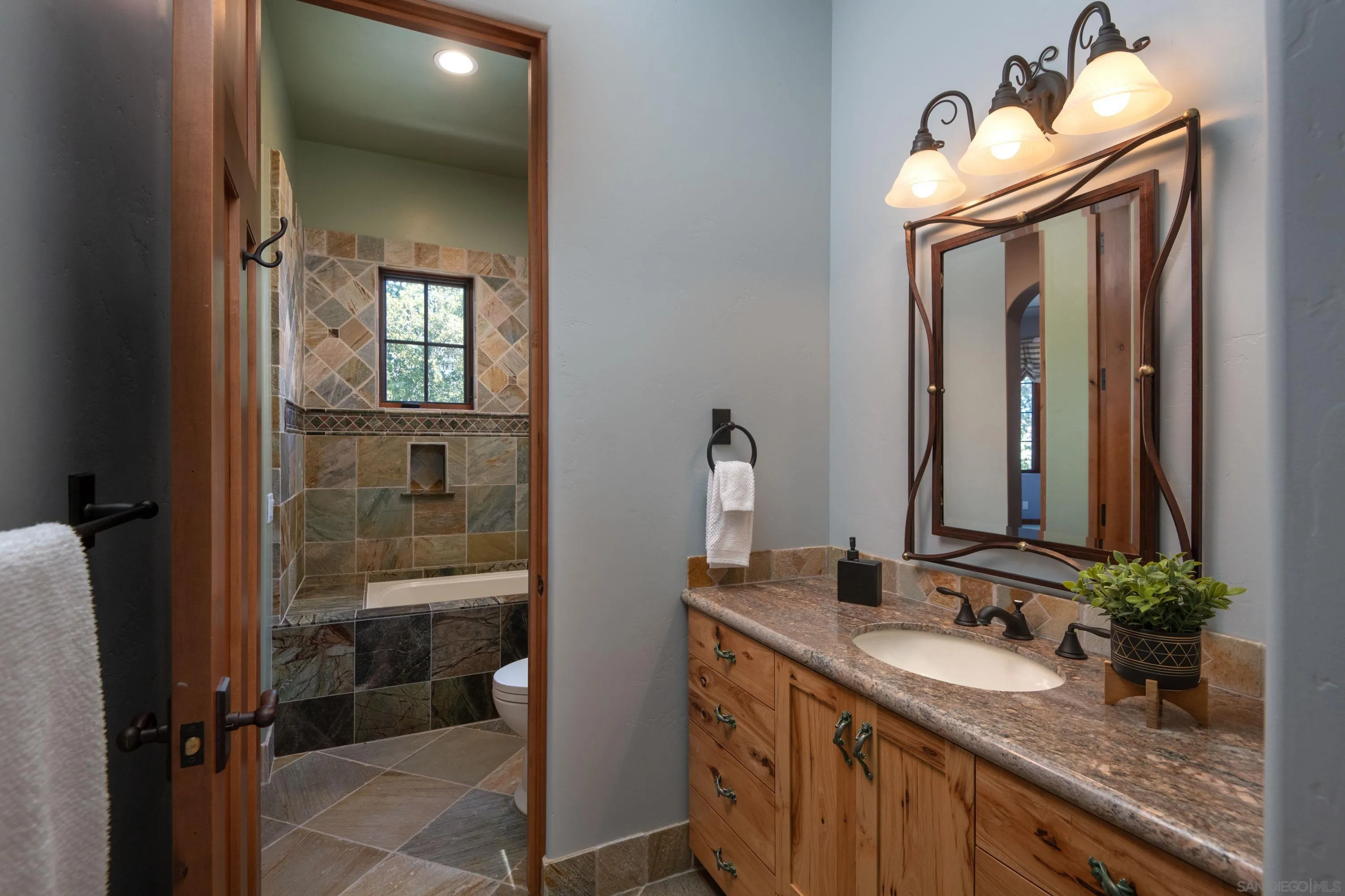 23835 Viejas Grade Road Descanso, CA 91916 - Photo 40 of 62 a bathroom with a granite countertop sink a mirror and a shower