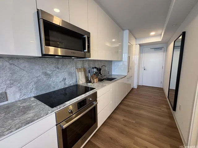 a kitchen with stainless steel appliances a stove microwave and sink