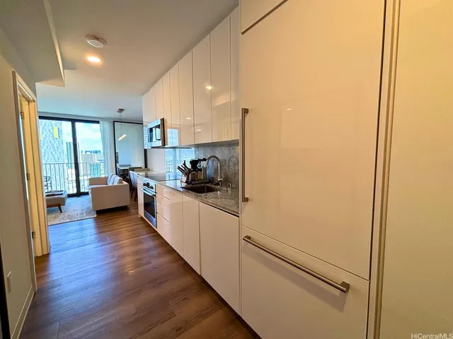 a kitchen with a refrigerator and white cabinets