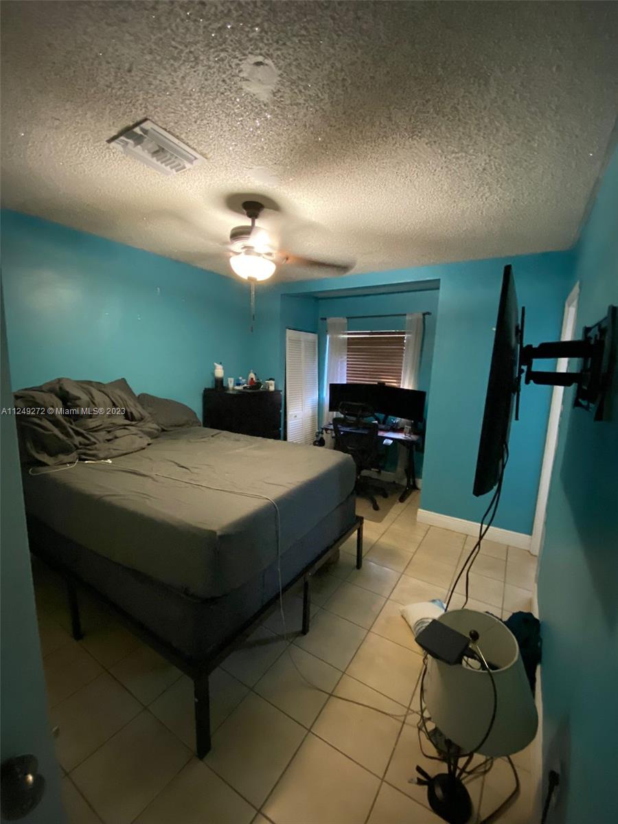 Sunset Miami, FL 33173 - Photo 13 of 18 a bedroom with a bed and a mirror