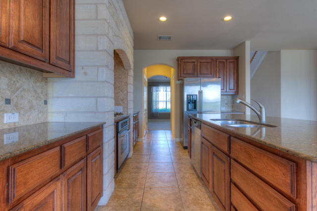 321 Limestone Trail Austin, TX 78737 - Photo 8 of 28 a large kitchen with stainless steel appliances granite countertop a large counter top a sink and a refrigerator