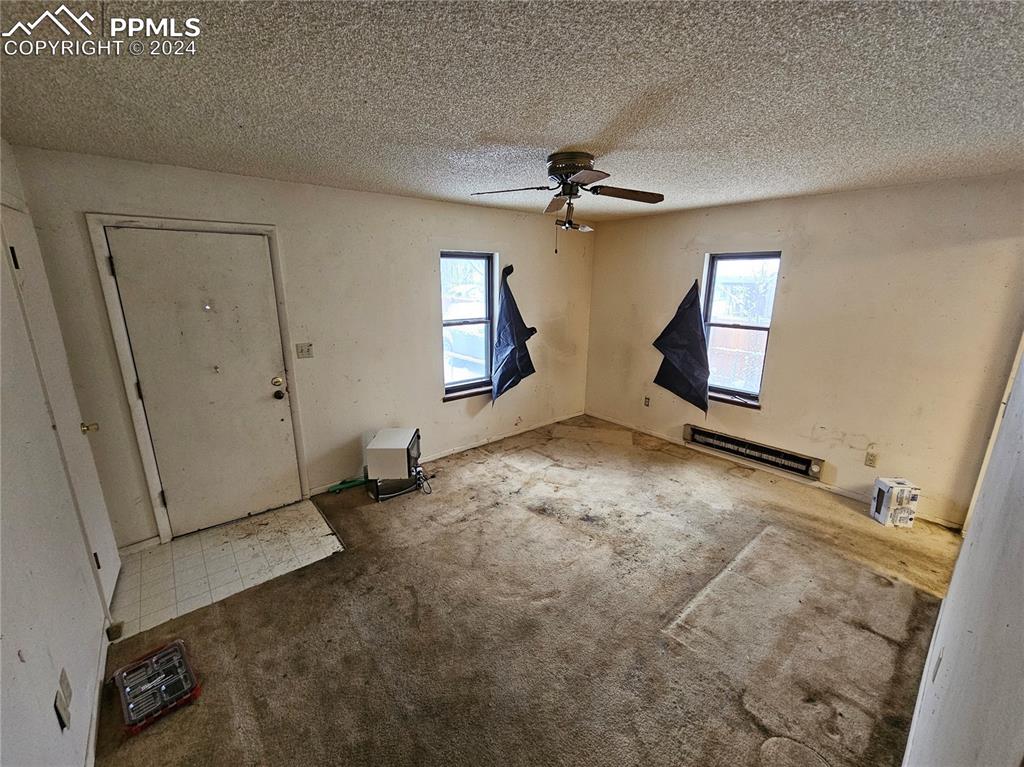 812 Alexander Road Colorado Springs, CO 80909 - Photo 6 of 8 wooden floor in an empty room with a window
