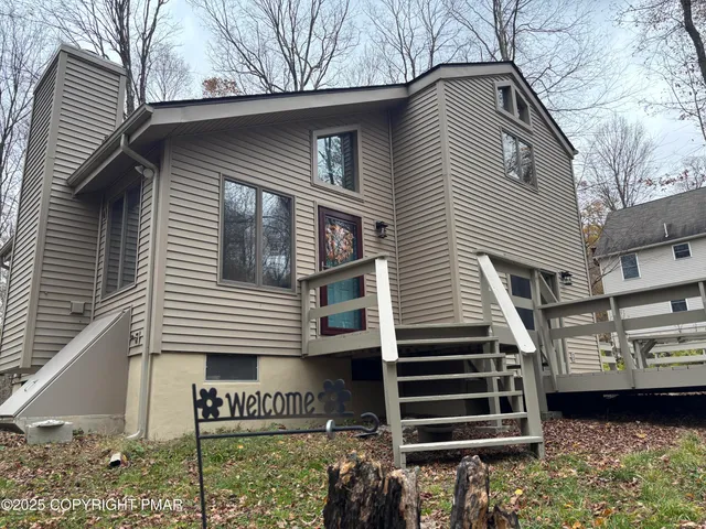 a front view of a house with a tree