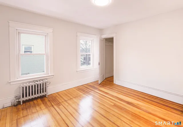 a view of an empty room with wooden floor