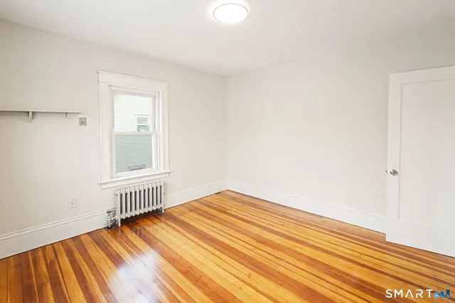 a view of an empty room with wooden floor