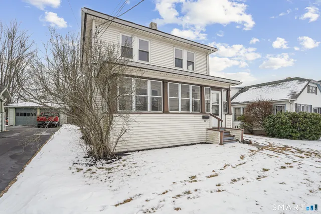 a front view of a house with a yard covered with snow