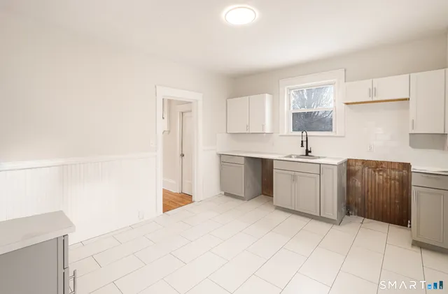 a view of a kitchen with white cabinets