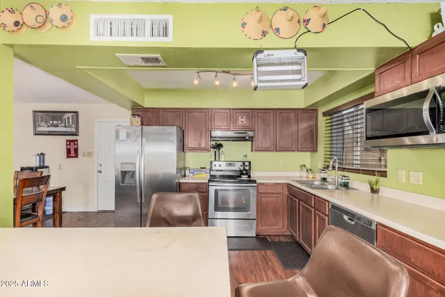 a kitchen with stainless steel appliances granite countertop a sink and a stove
