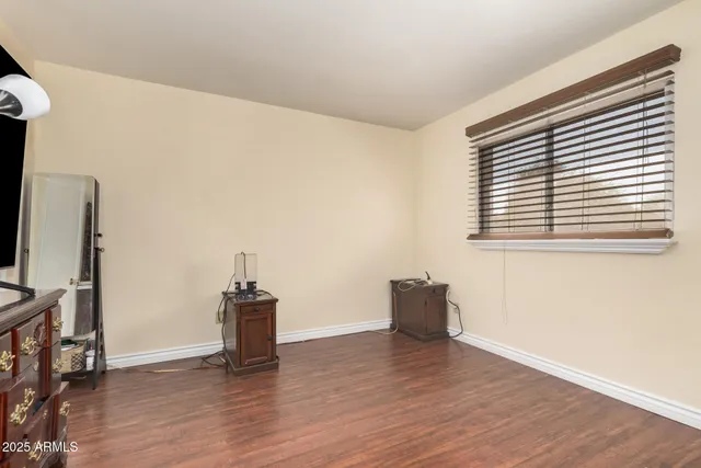 a view of empty room with wooden floor and furniture