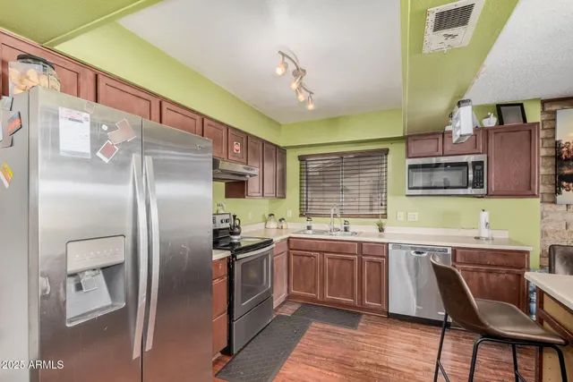 a kitchen with stainless steel appliances granite countertop a sink stove and refrigerator