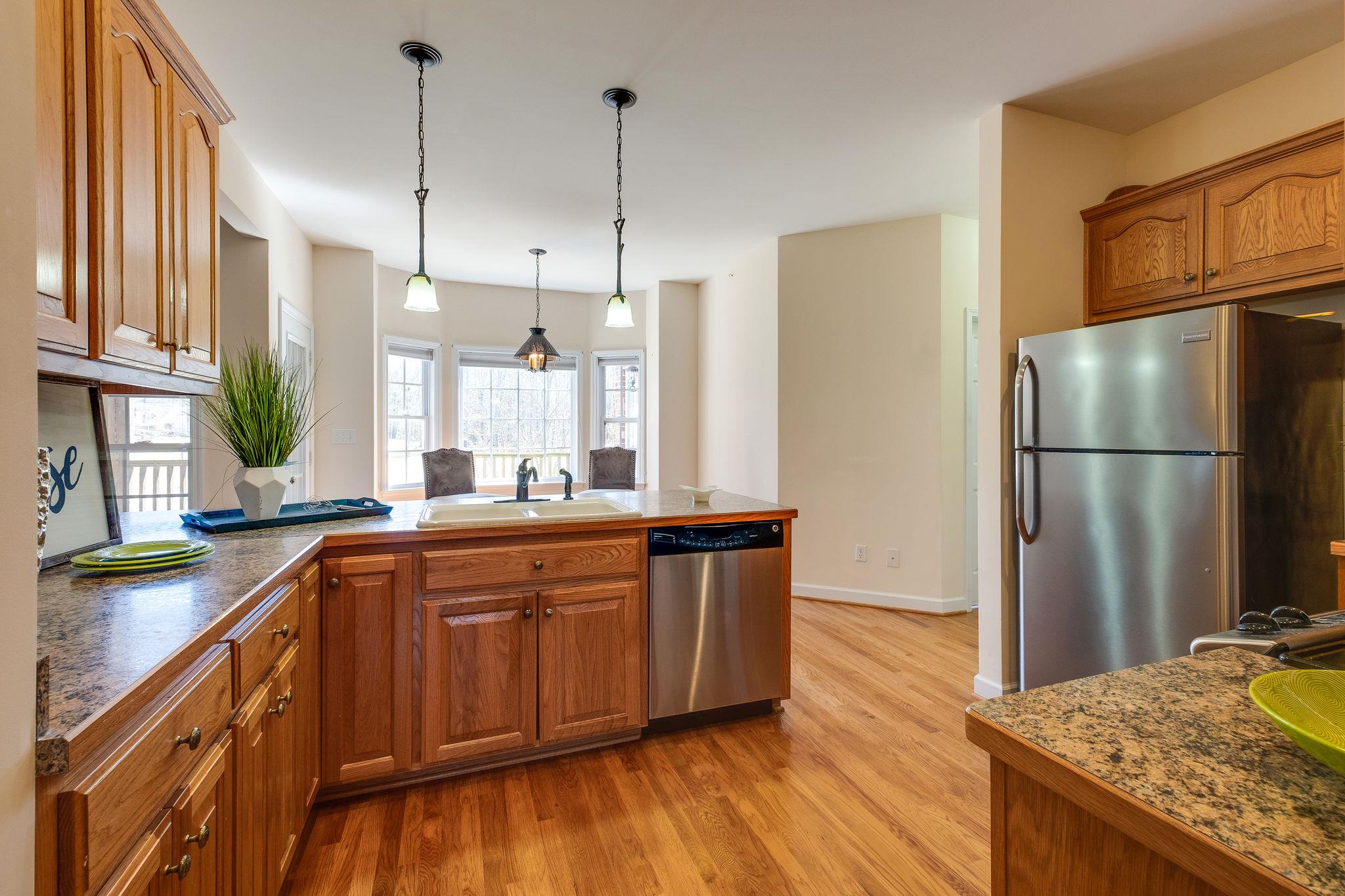 1175 Tidwell Switch Road Dickson, TN 37055 - Photo 12 of 27 a kitchen with stainless steel appliances granite countertop a refrigerator a sink dishwasher a stove and white countertops with wooden floor