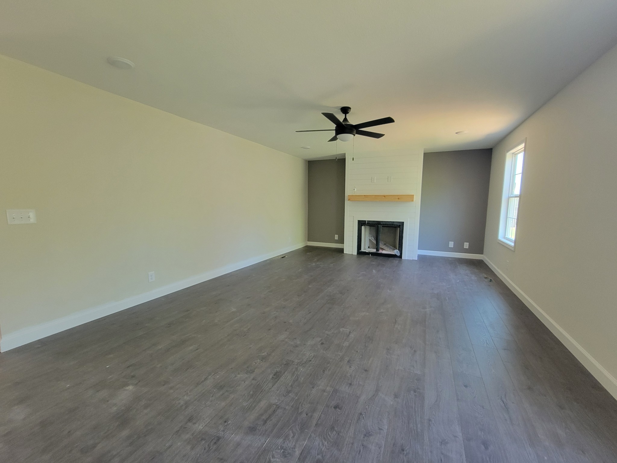 2265 Mockingbird Hill Road Palmyra, TN 37142 - Photo 6 of 24 an empty room with a fireplace and wooden floor