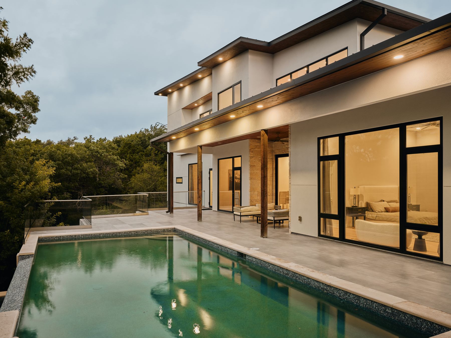 2476 Waymaker Way Austin, TX 78746 - Photo 3 of 31 An impressive exterior features a shimmering pool alongside a private patio, perfect for evening relaxation.