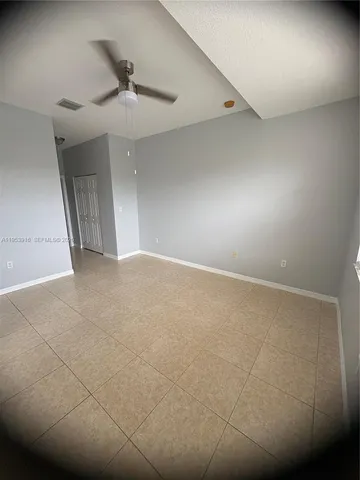 an empty room with a ceiling fan and a window