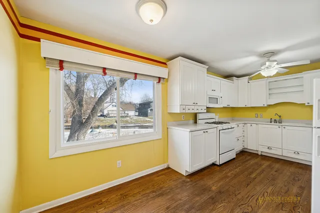 a large kitchen with a wooden floor and a window