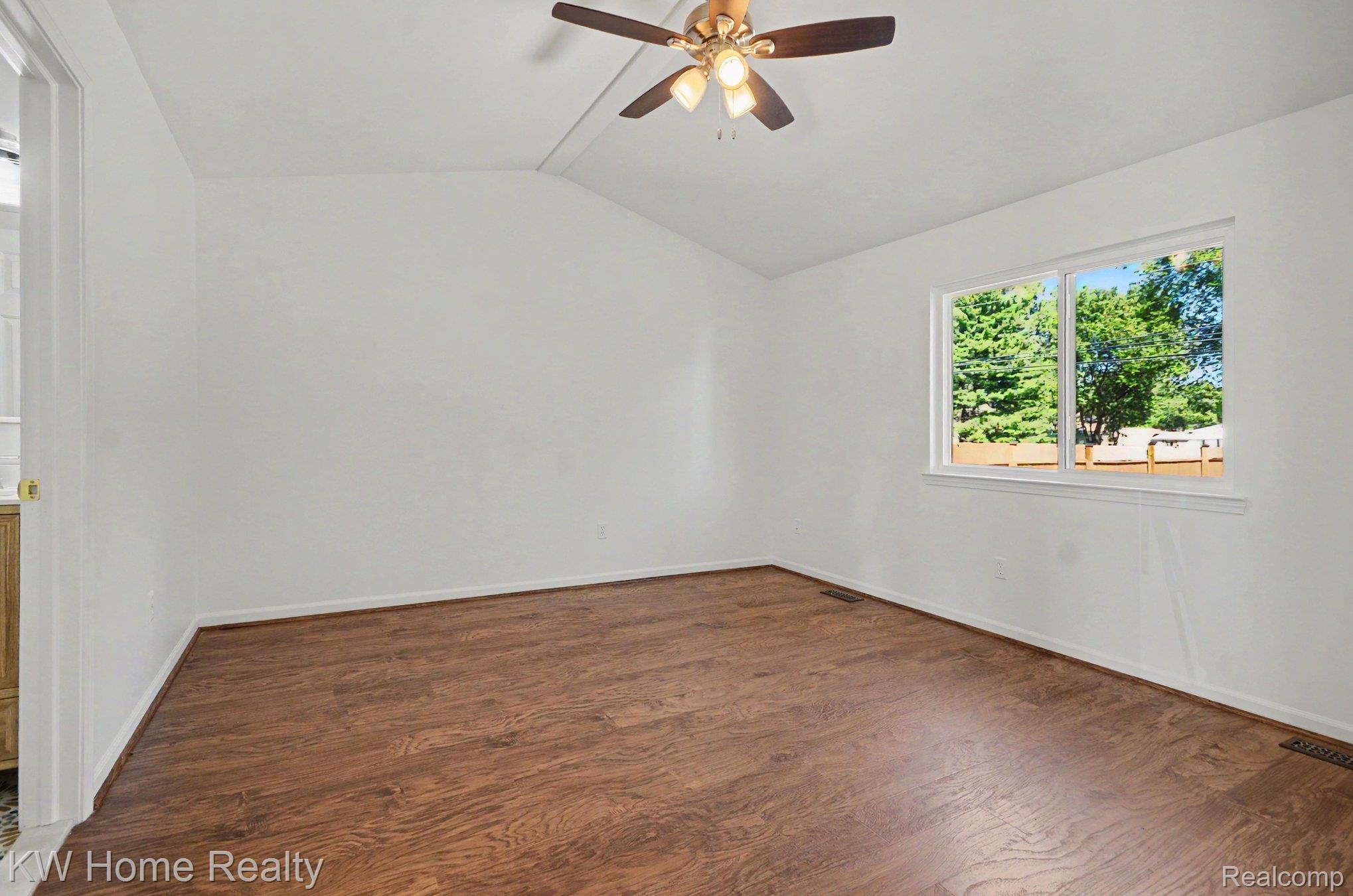 2383 East Maple Road Troy, MI 48083 - Photo 14 of 25 Vaulted ceiling with a ceiling fan, wood-finish flooring, and a large window