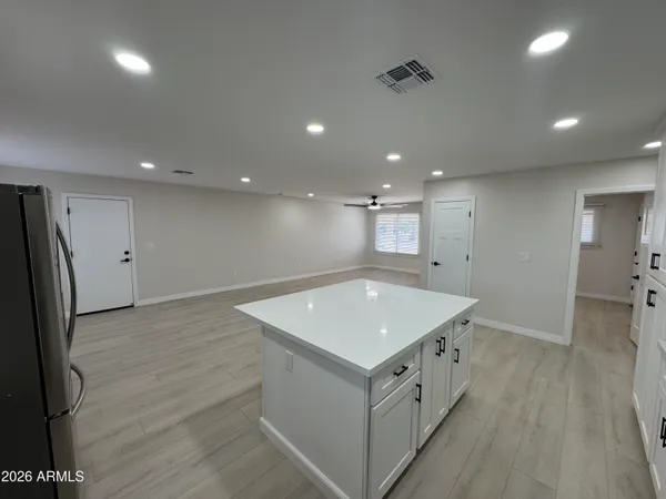 a view of a room with wooden floor and a ceiling fan