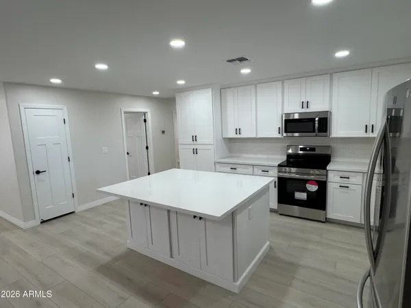 a kitchen with a refrigerator sink and cabinets