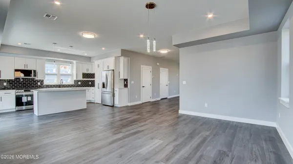 a large kitchen with stainless steel appliances granite countertop a refrigerator and a stove top oven