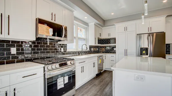 a kitchen with stainless steel appliances a stove microwave and refrigerator