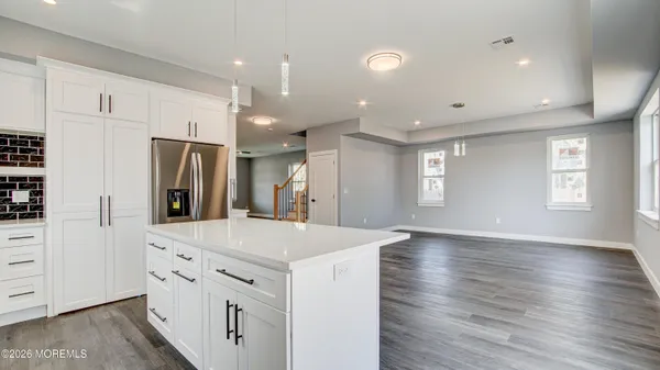 a kitchen with stainless steel appliances a refrigerator and wooden floor