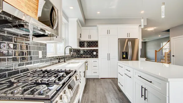 a kitchen with stainless steel appliances kitchen island granite countertop a stove and a refrigerator