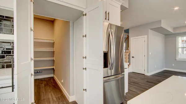a kitchen with a refrigerator and wooden floor