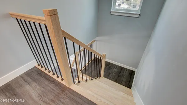 a view of a hallway with wooden floor and stairs